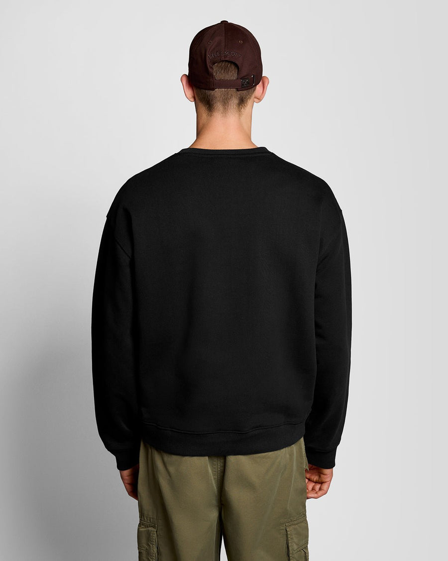 Un homme porte un sweat-shirt épais à imprimé script, couleur noir de jais