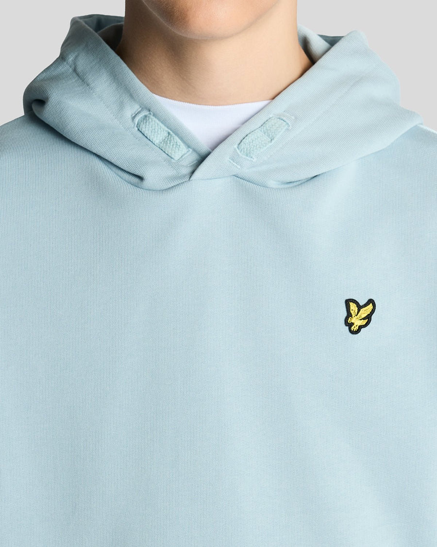 Un homme porte un sweat à capuche en coton Loopback bleu opale