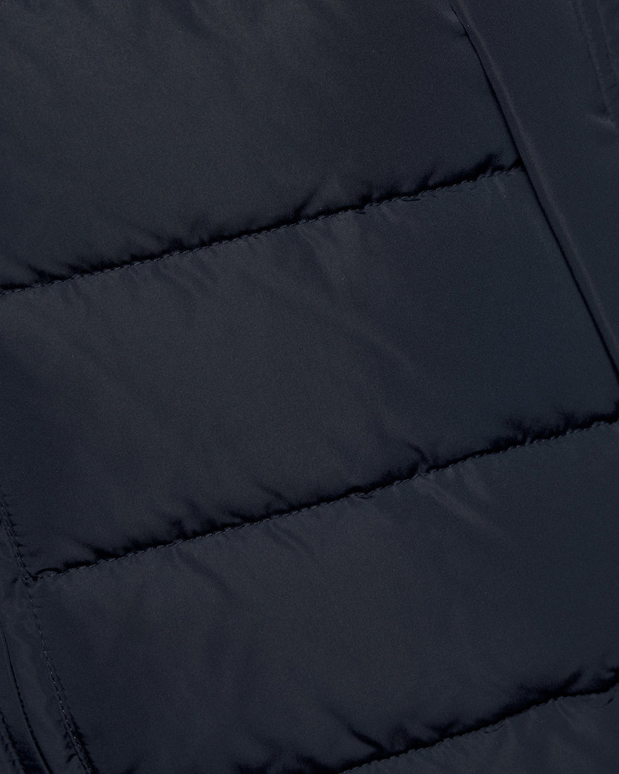 Un homme porte un gilet matelassé bleu marine foncé