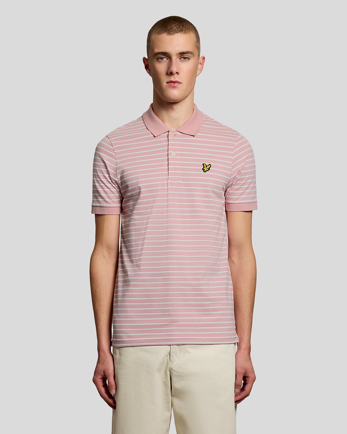 Homme portant un polo breton en piqué rose pamplemousse et blanc