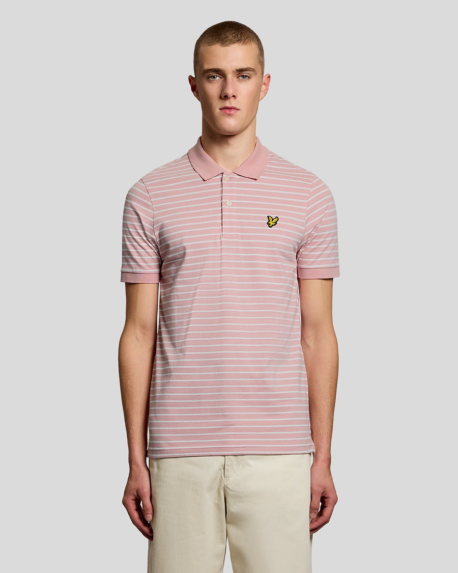 Homme portant un polo breton en piqué rose pamplemousse et blanc