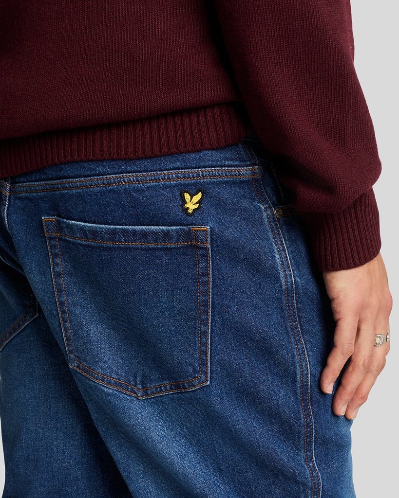 Homme portant un jean en denim ajusté et fuselé, couleur indigo