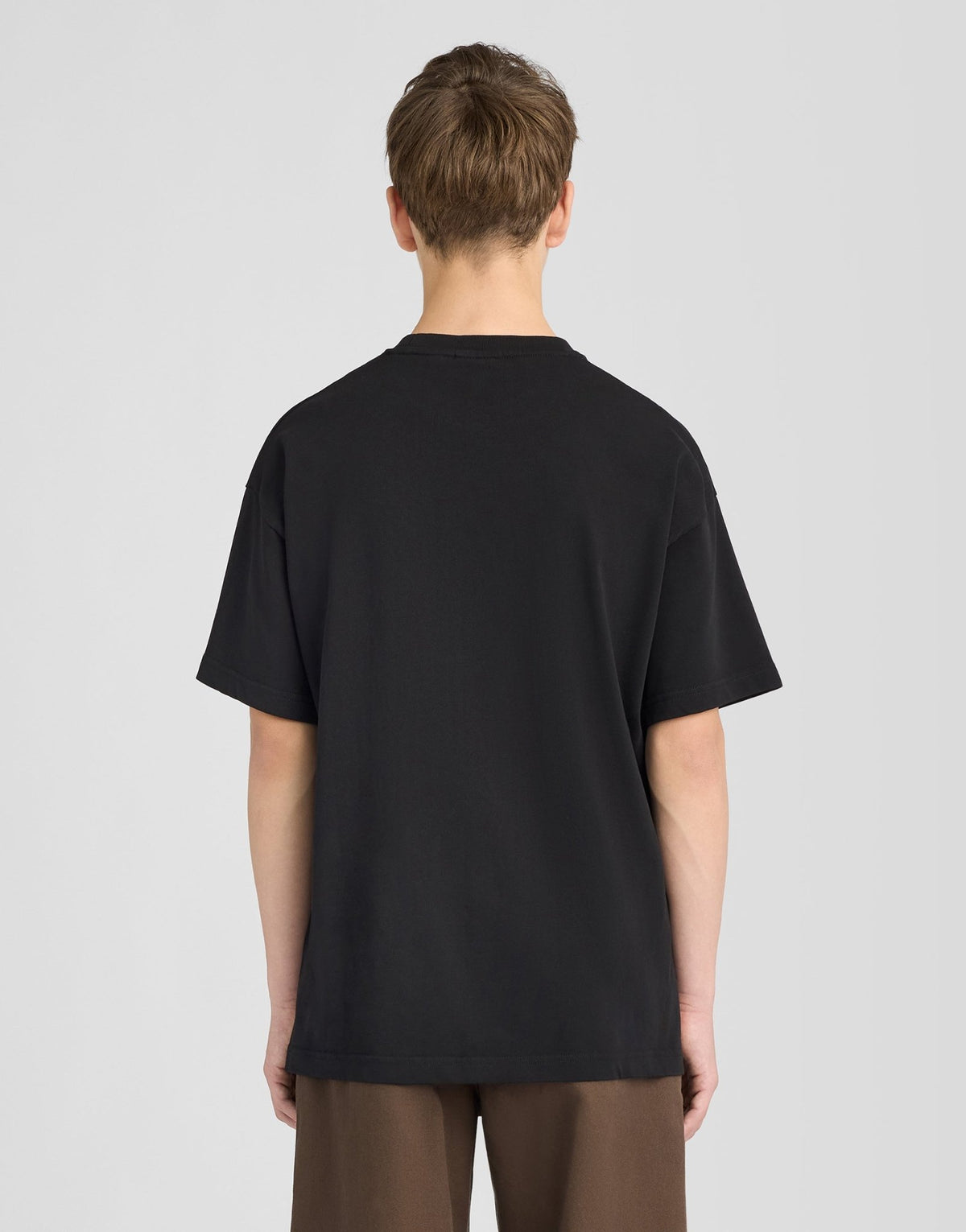 Garçon portant un t-shirt ample épais, couleur noire