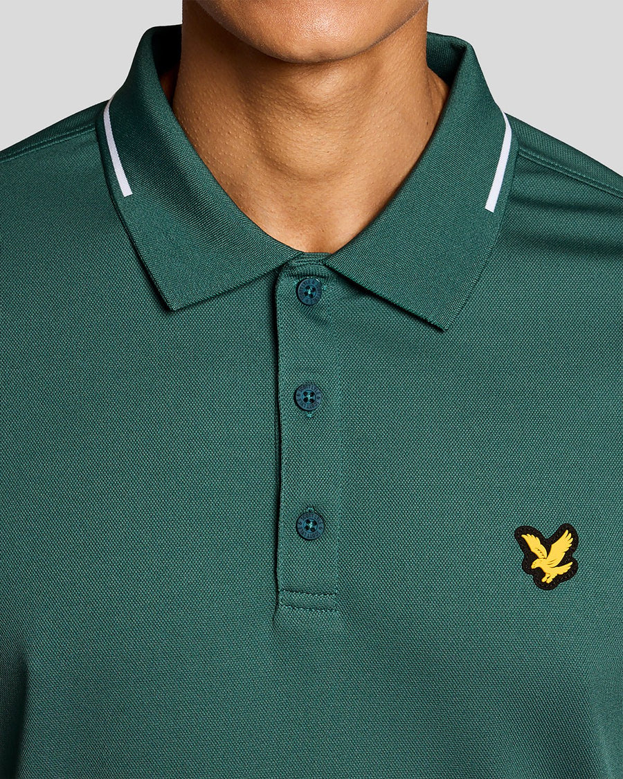 Un homme porte un polo technique à bordures dans la collection Mediterranea