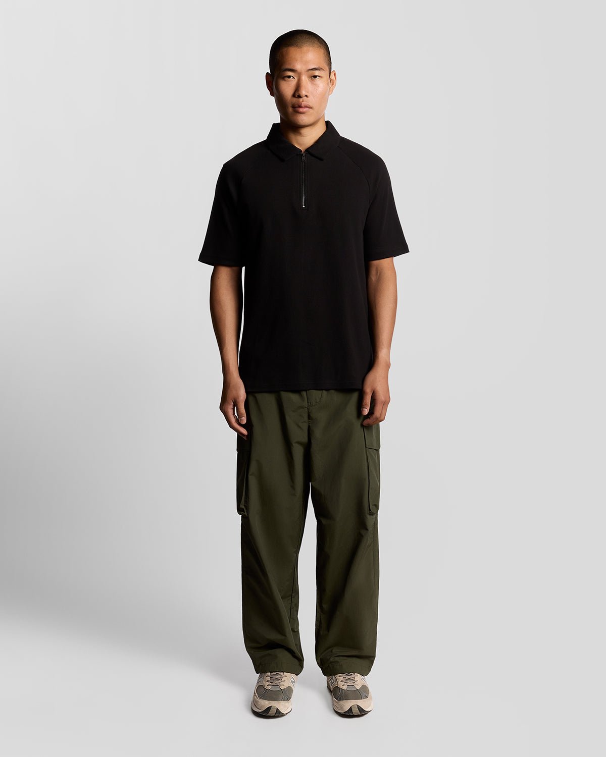 Man wears Interlock Zipped Polo Shirt in Jet Black