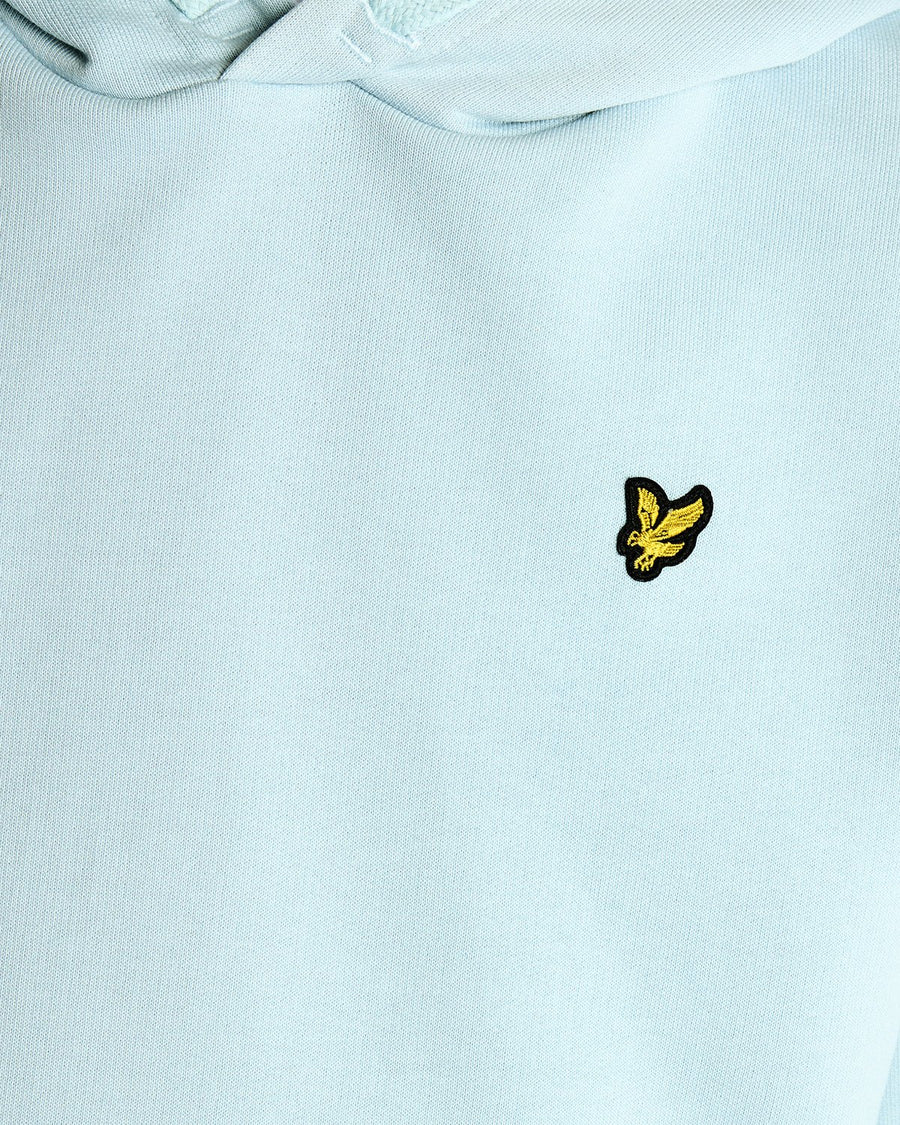 Un homme porte un sweat à capuche en coton Loopback bleu opale