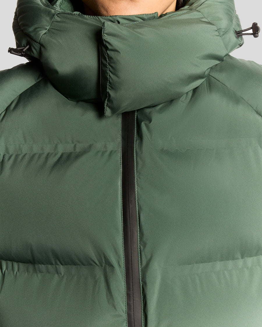 Homme portant un gilet matelassé à capuche épais, couleur Dark Pine