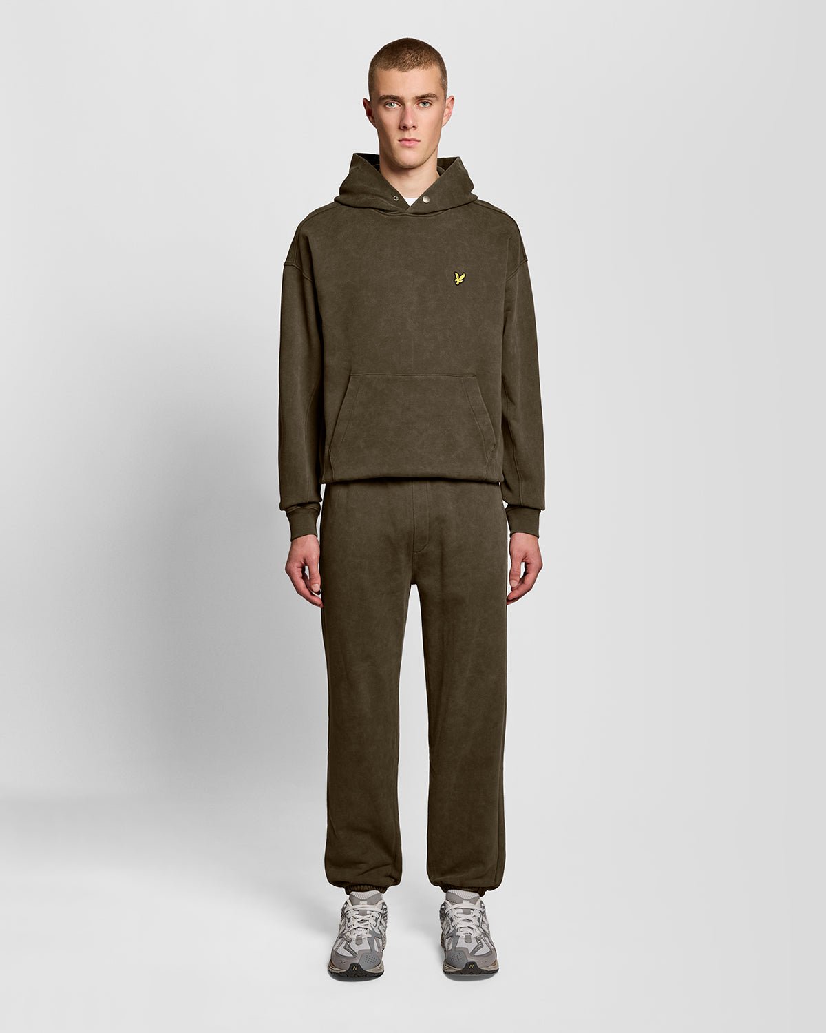 Un homme porte un pantalon de jogging en coton délavé foncé, couleur noir mat