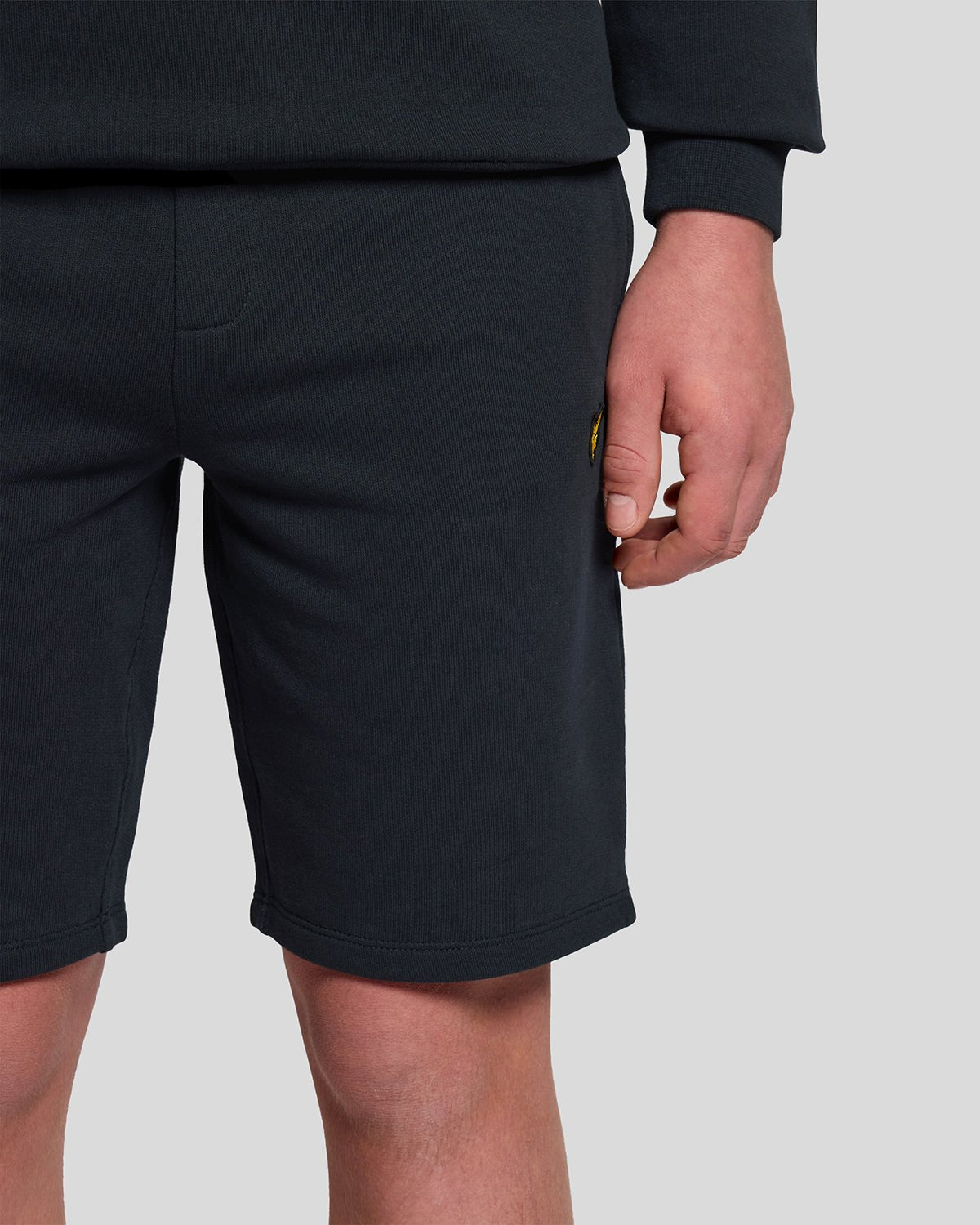 Un homme porte un short de survêtement en coton bleu marine foncé