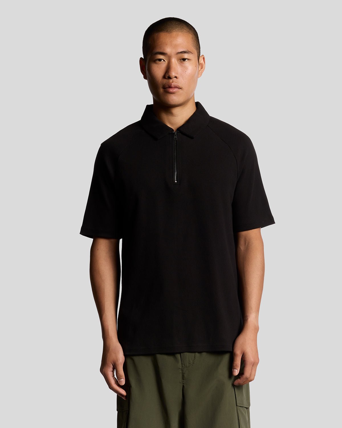 Man wears Interlock Zipped Polo Shirt in Jet Black