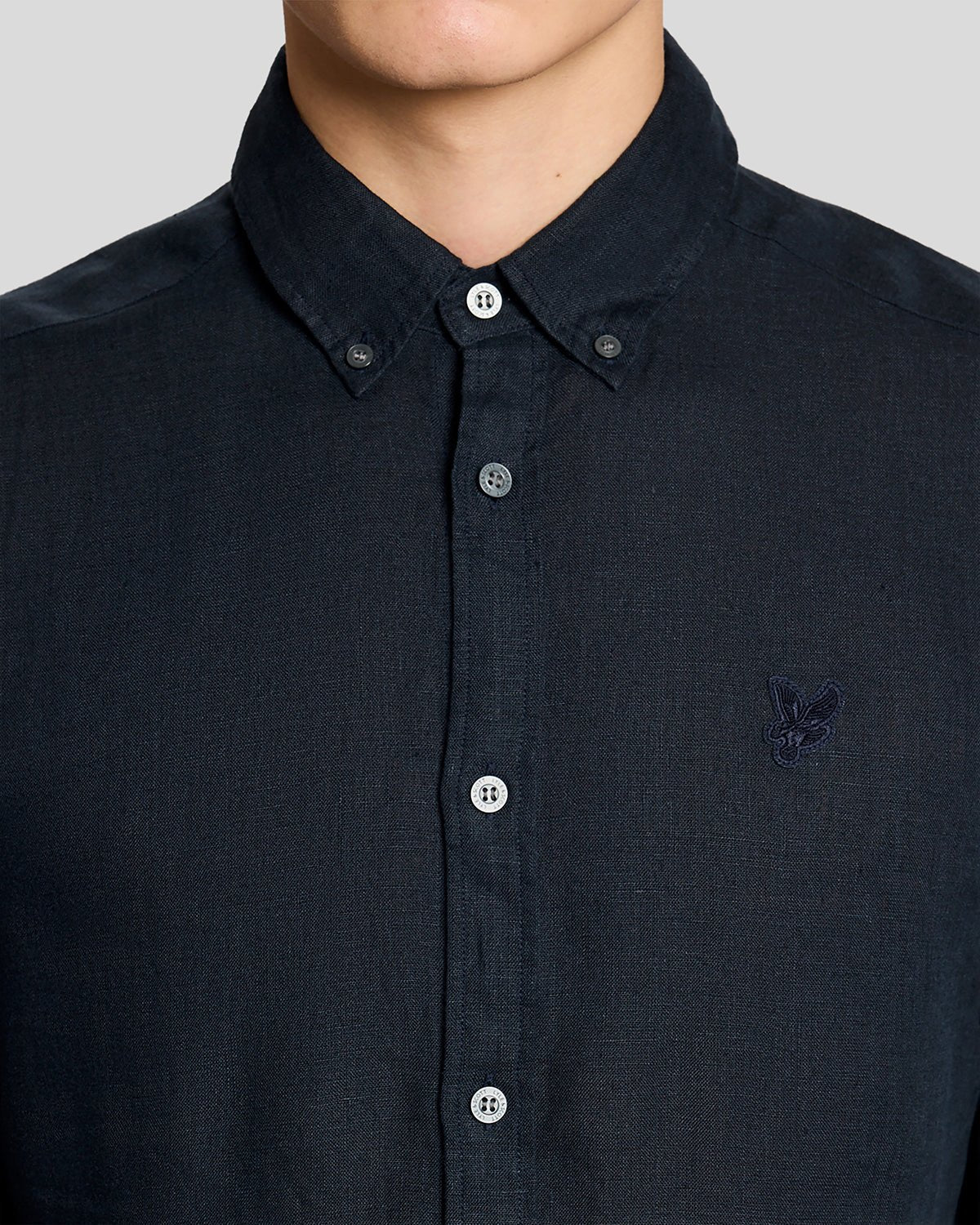 Un homme porte une chemise boutonnée en lin couleur carbone
