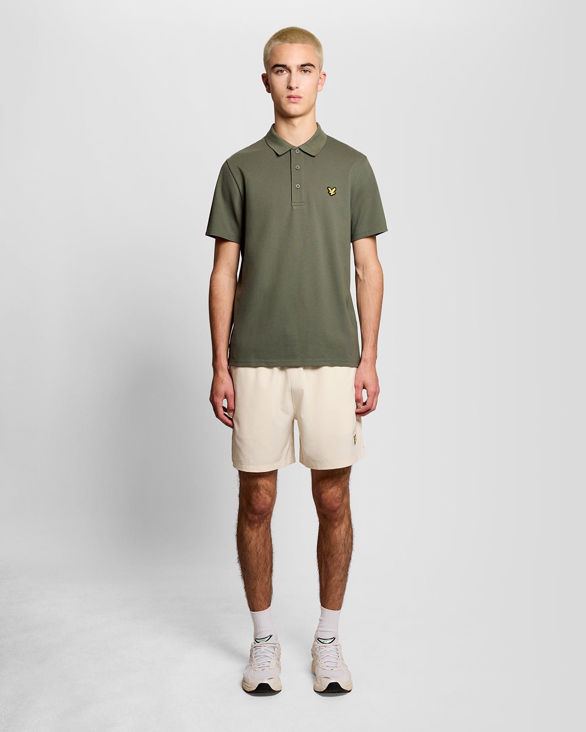 Un homme porte un polo de sport vert cactus