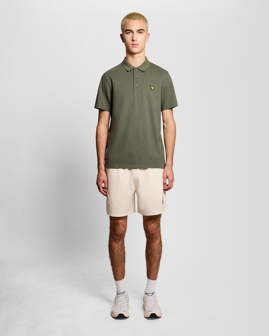 Un homme porte un polo de sport vert cactus