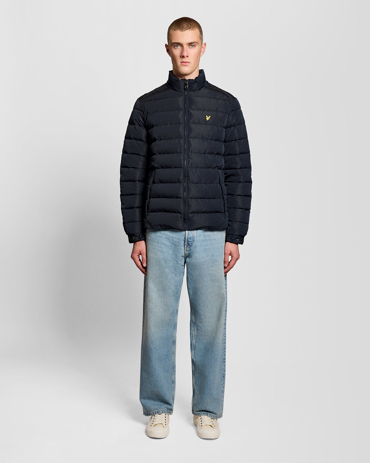 Un homme porte une veste matelassée bleu marine foncé