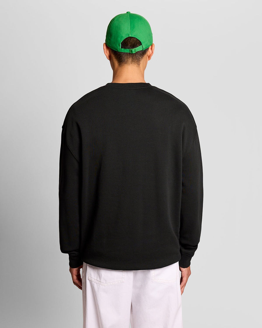 Homme portant un sweat-shirt à imprimé sur la poitrine, couleur noir de jais