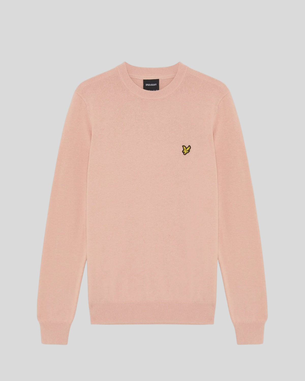 Homme portant un pull à col rond en coton couleur pamplemousse rose