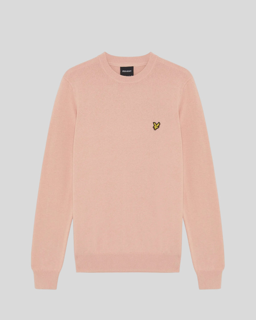 Homme portant un pull à col rond en coton couleur pamplemousse rose