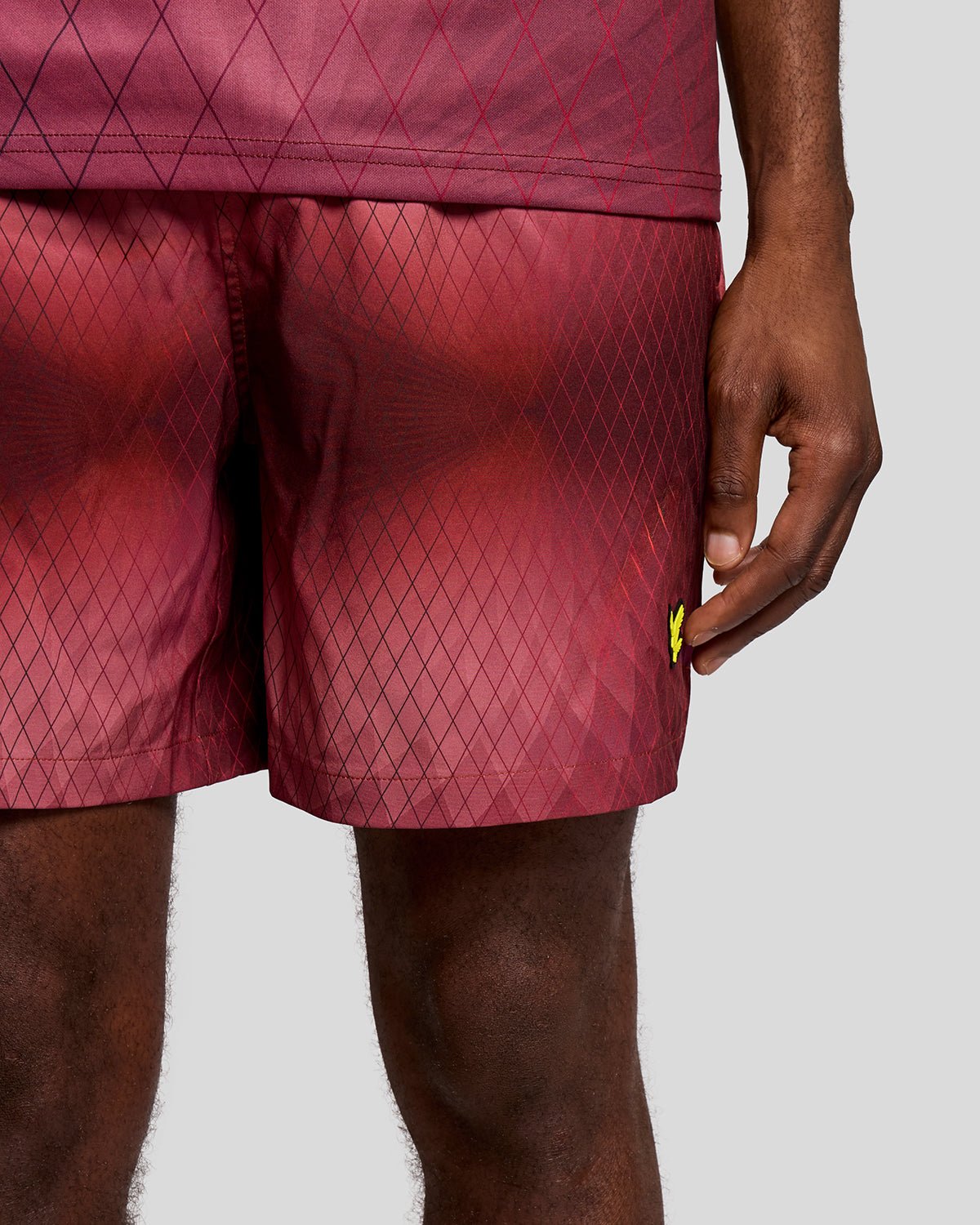 Un homme porte un short de bain Monogram Geometric couleur figue