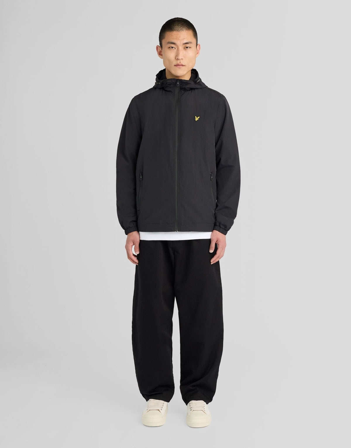 Hombre con chaqueta con capucha impermeable y costuras selladas en negro azabache