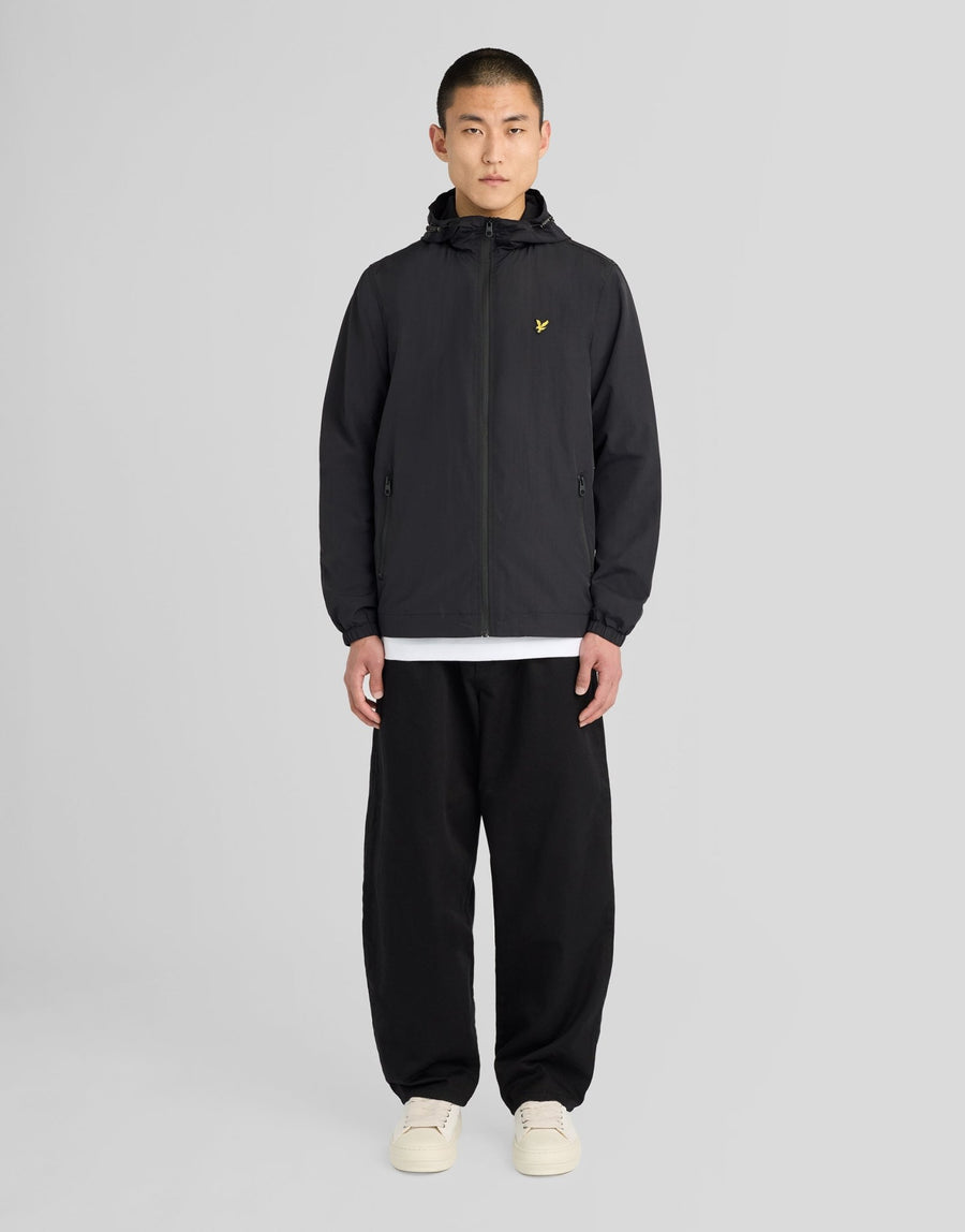 Hombre con chaqueta con capucha impermeable y costuras selladas en negro azabache