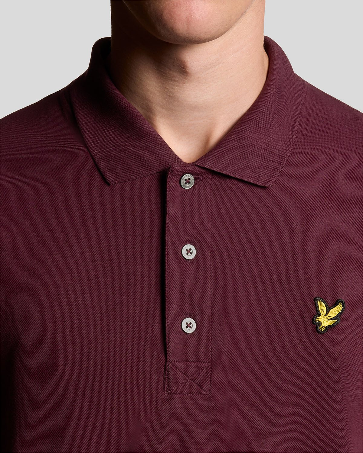Un homme porte un polo en coton bordeaux