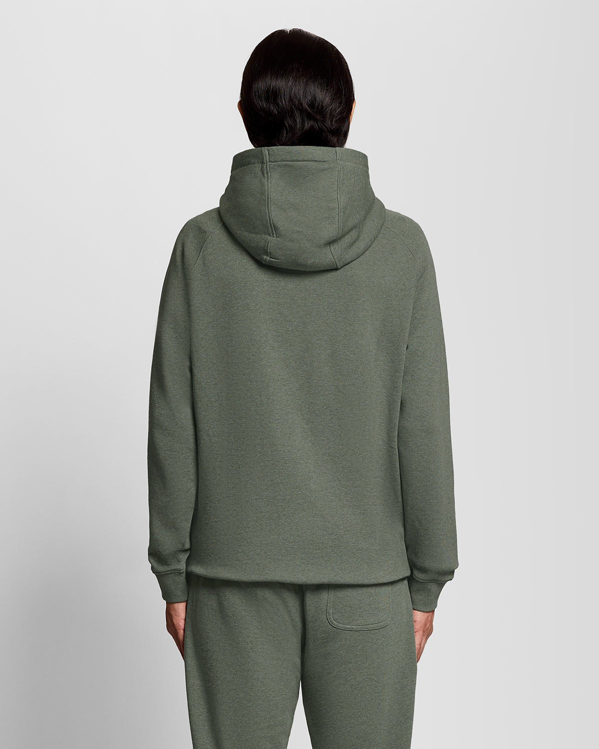 Un homme porte un sweat à capuche raglan en coton chiné, couleur kaki tricolore