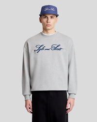 Man wears Script Logo Crew Neck Sweatshirt in grey