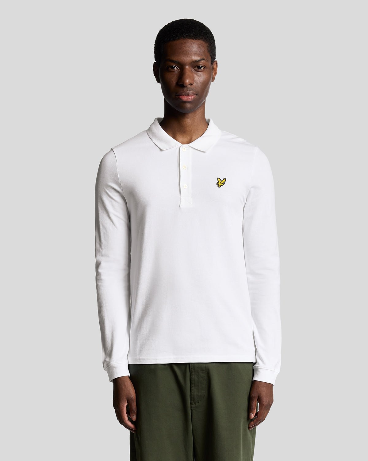 Un homme porte un polo en coton à manches longues blanc