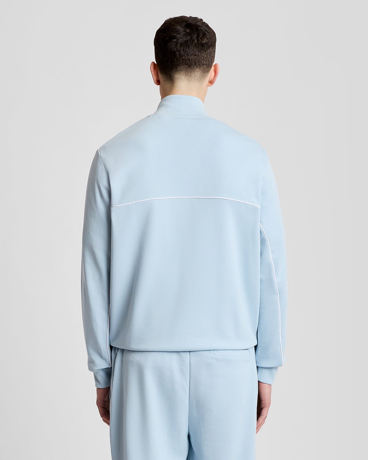 Homme portant un sweat à capuche zippé intégral à passepoil, couleur bleu opale