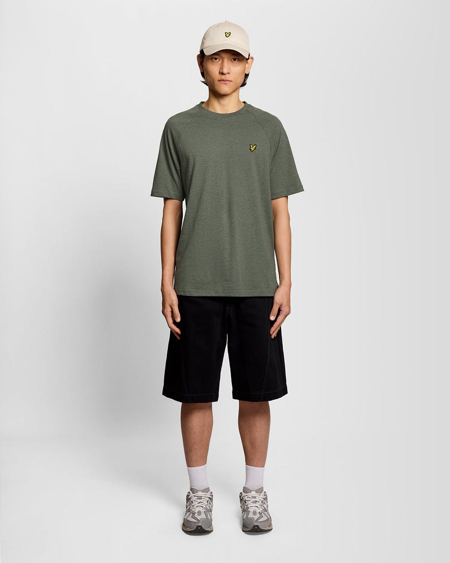 Un homme porte un t-shirt Marl Raglan de couleur kaki Tri Marl