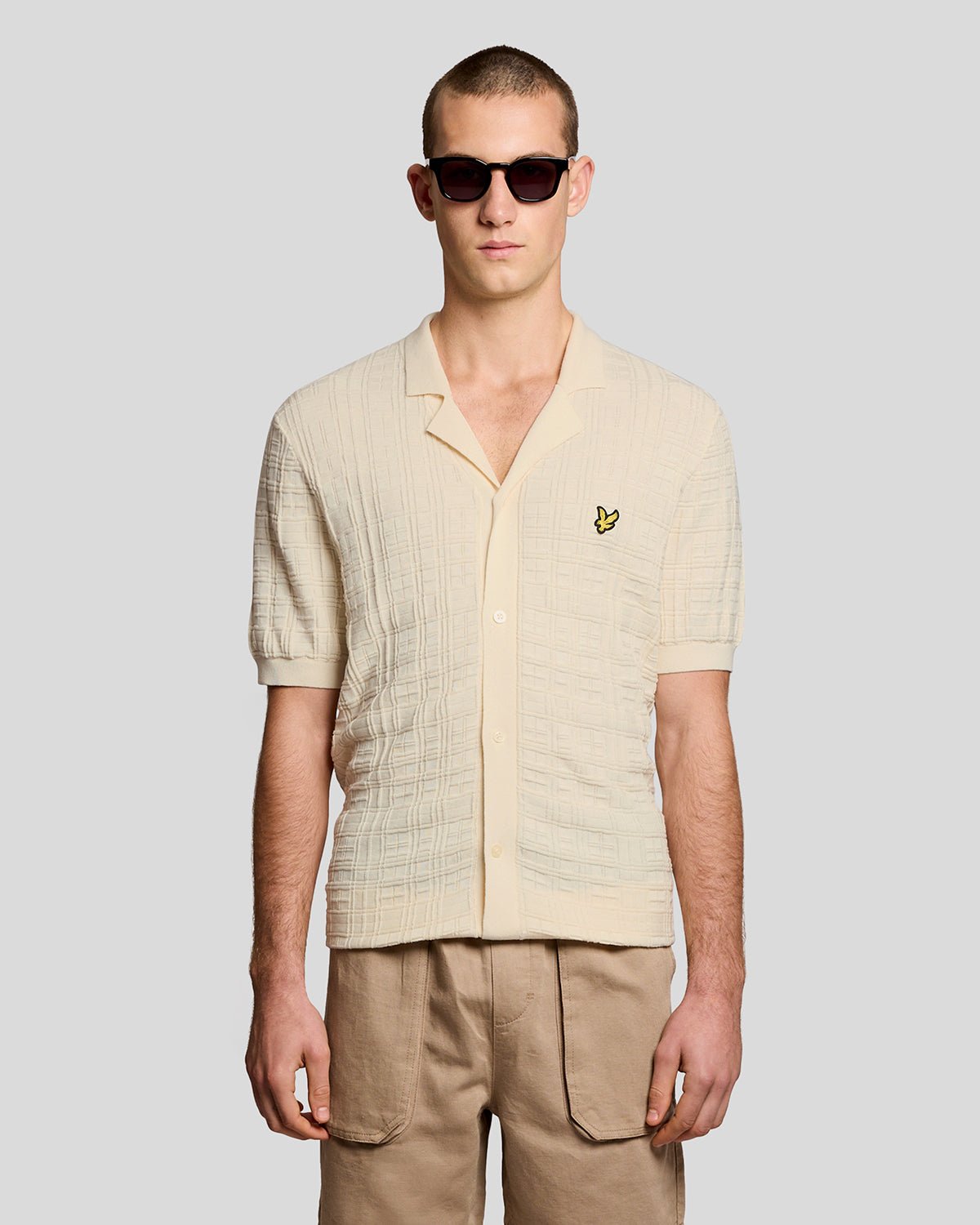Un homme porte une chemise de vacances en maille à col Revere, couleur « Ice Cream »