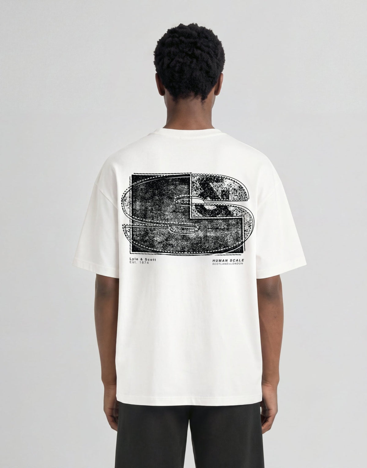 Pojke bär en vit T-shirt med halvtonat monogramtryck