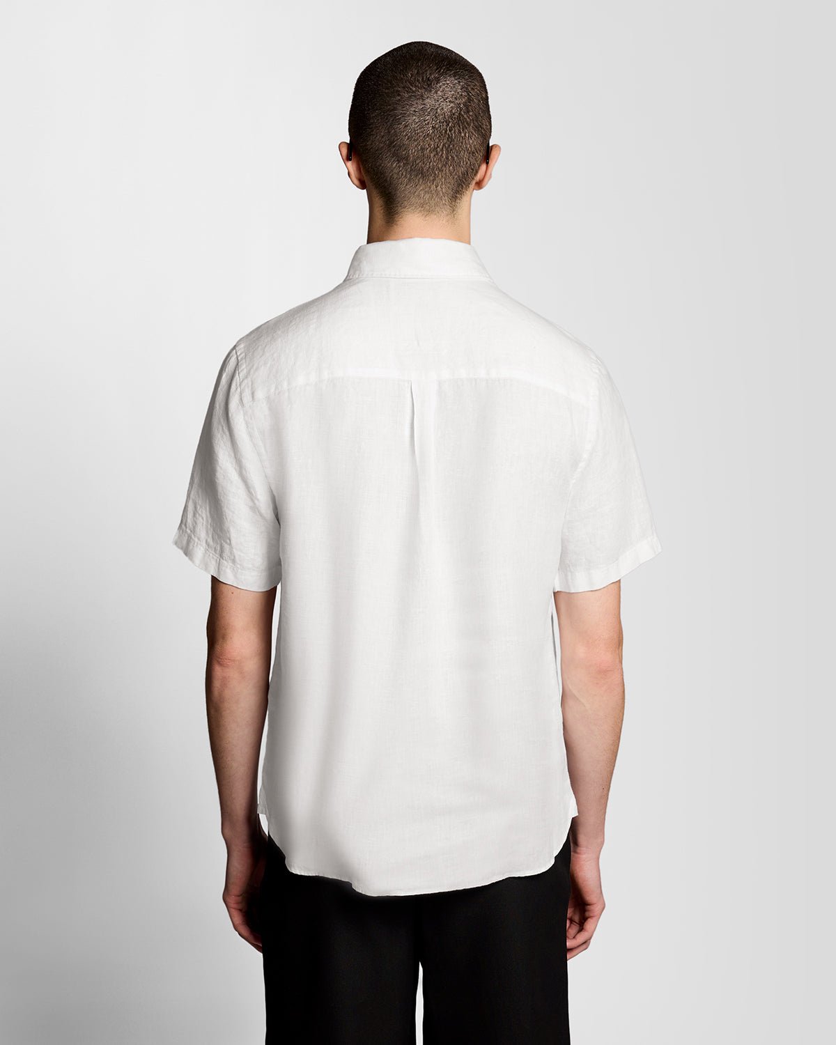 Un homme porte une chemise en lin à manches courtes blanche