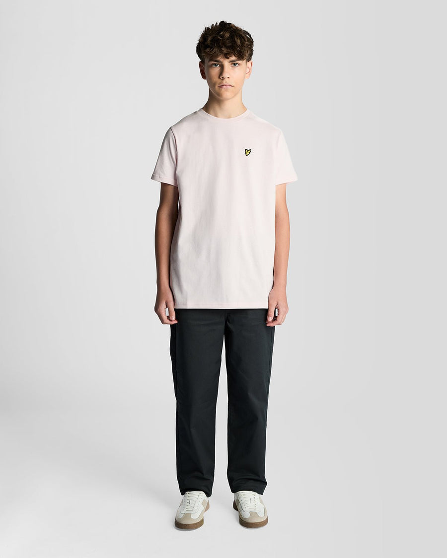 Un homme porte un t-shirt à col rond en coton rose pâle