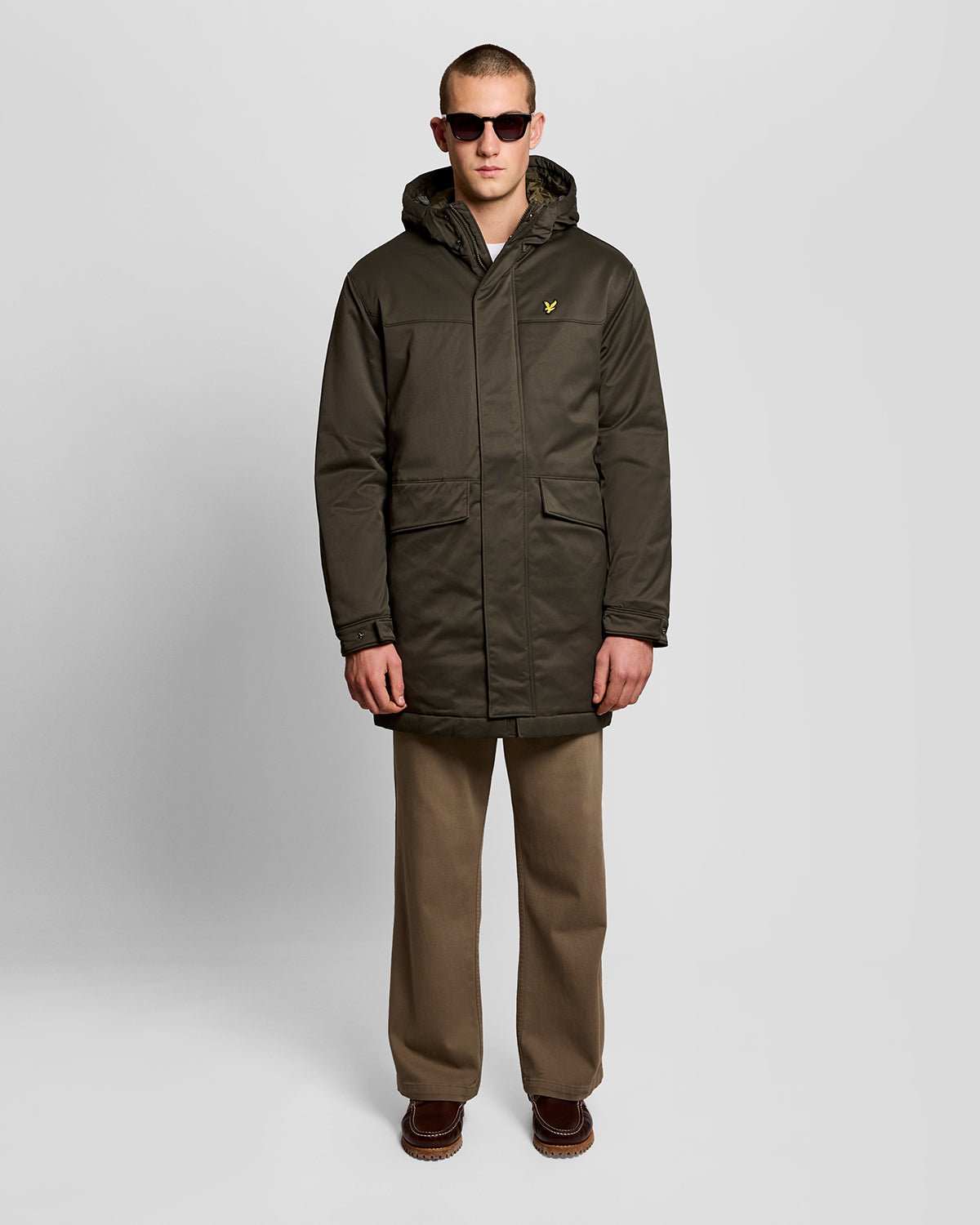 Un homme porte une parka matelassée de couleur olive