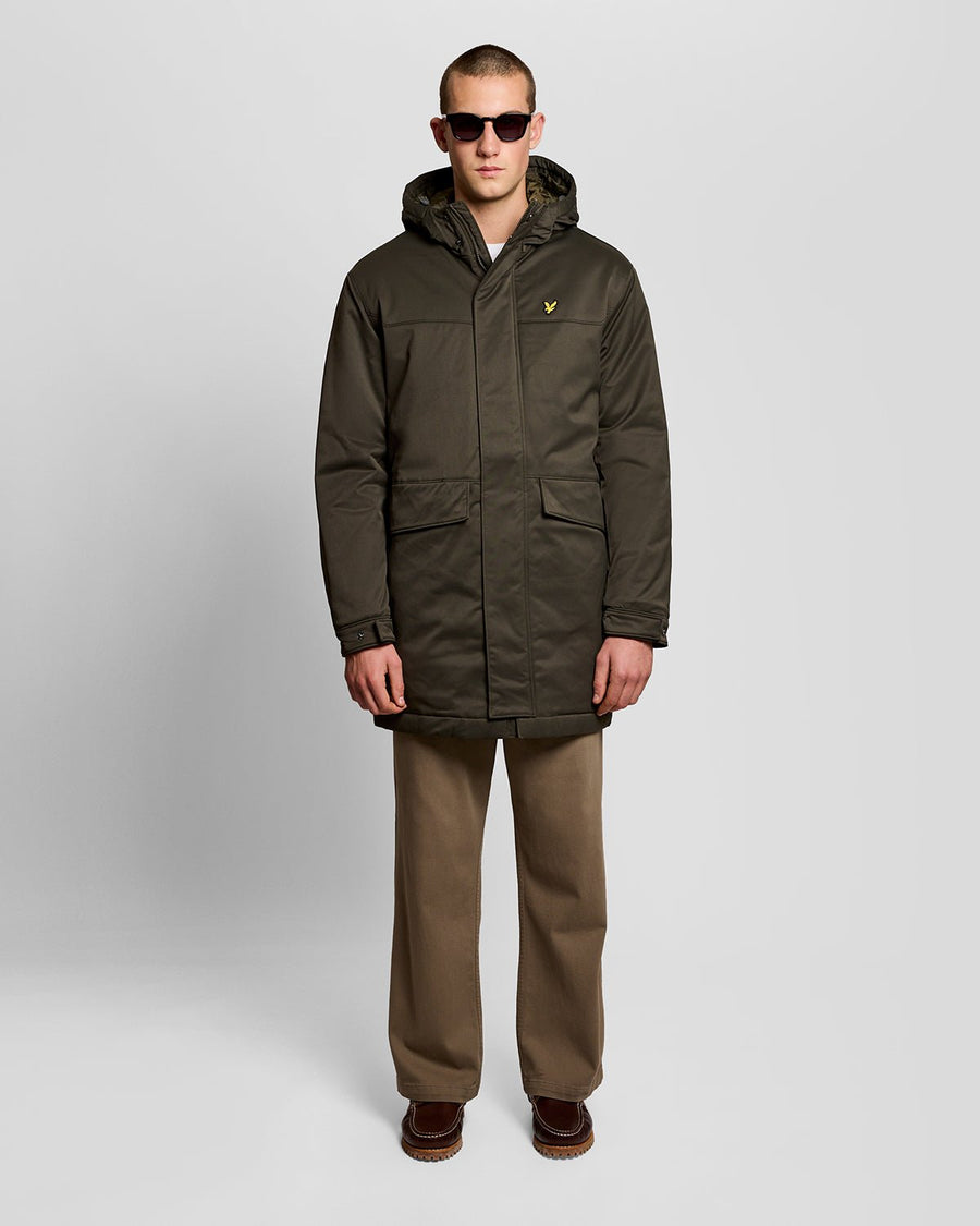 Un homme porte une parka matelassée de couleur olive