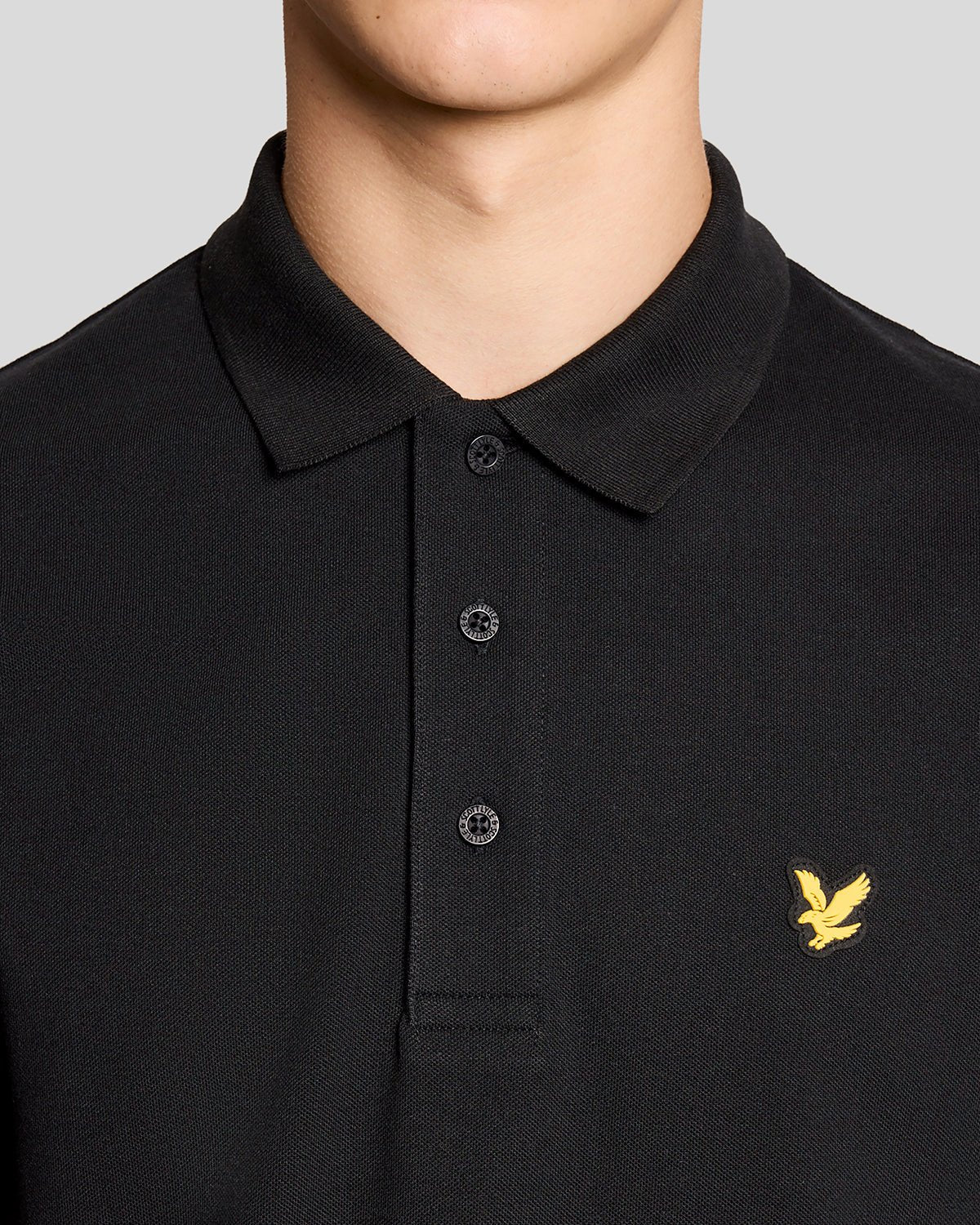 Un homme porte un polo de sport noir de jais