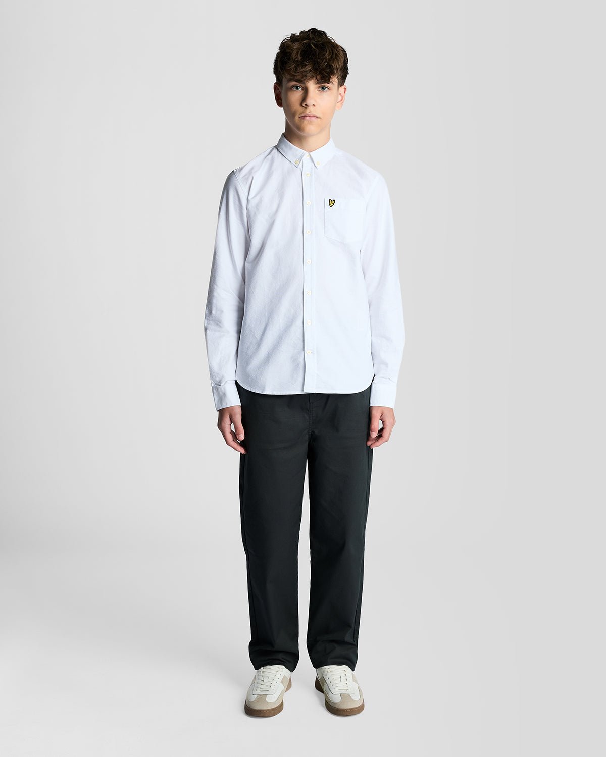 Un homme porte une chemise Oxford en coton à boutons, de couleur blanche