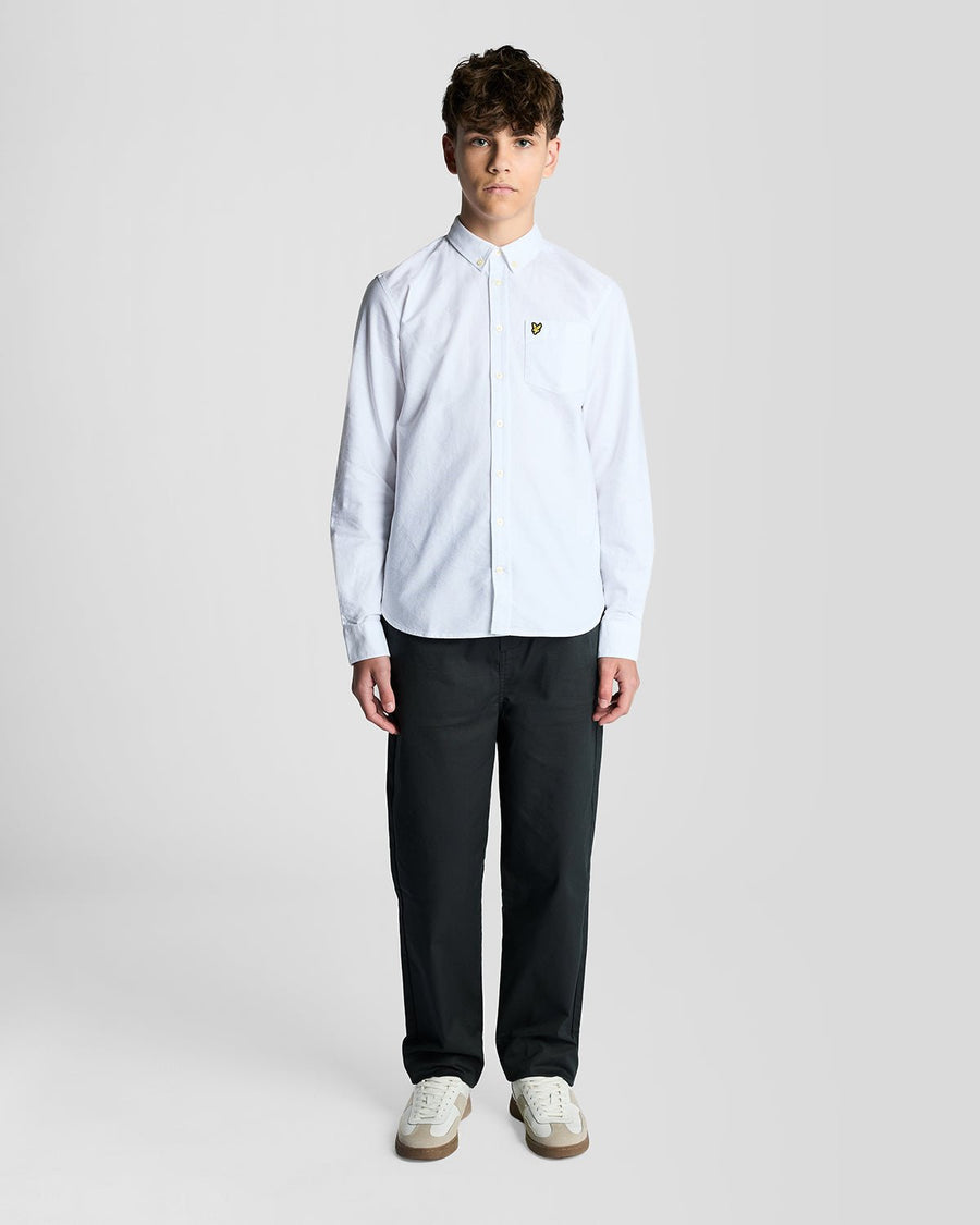 Un homme porte une chemise Oxford en coton à boutons, de couleur blanche