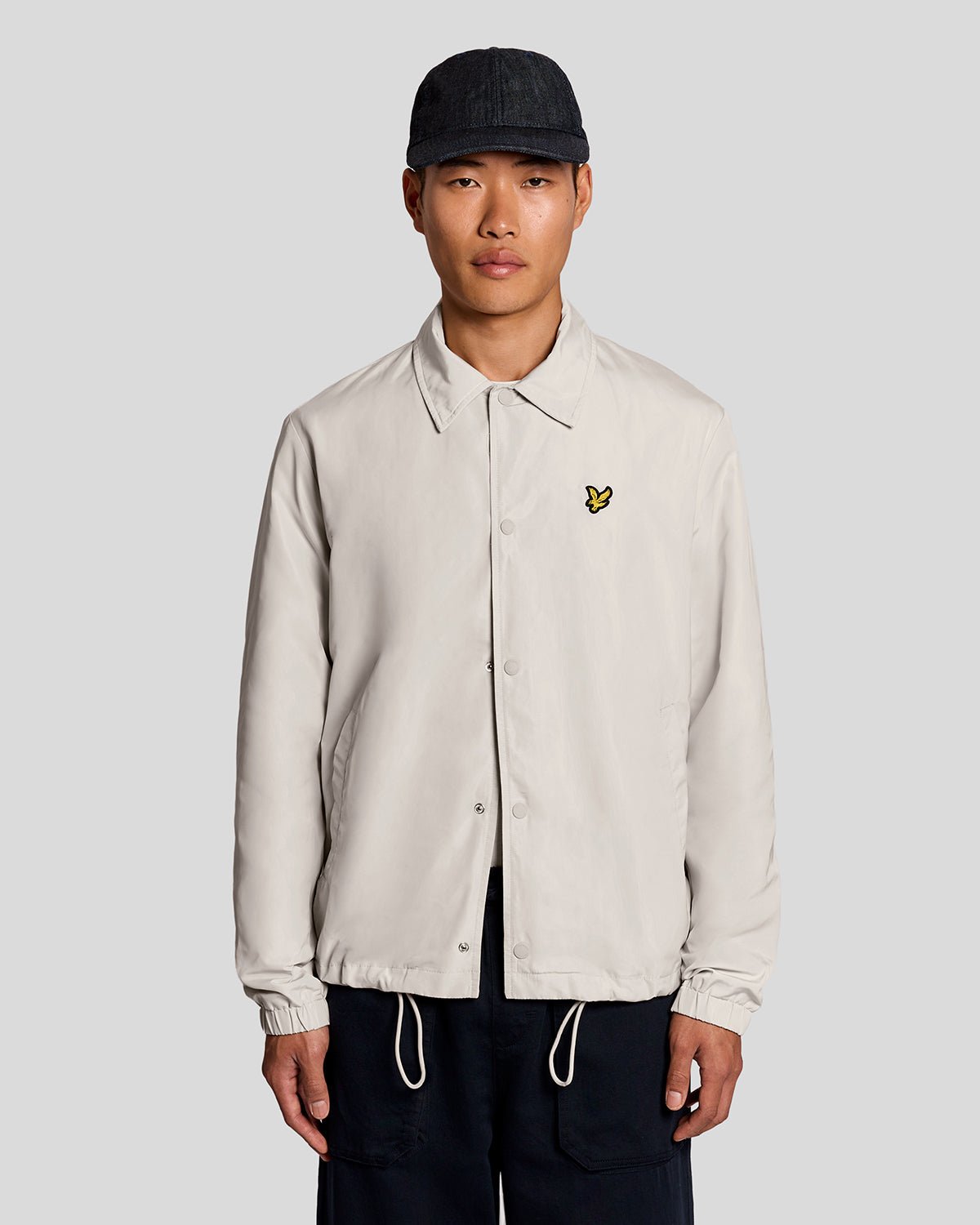 Un homme porte une veste Coach légère de couleur Cove