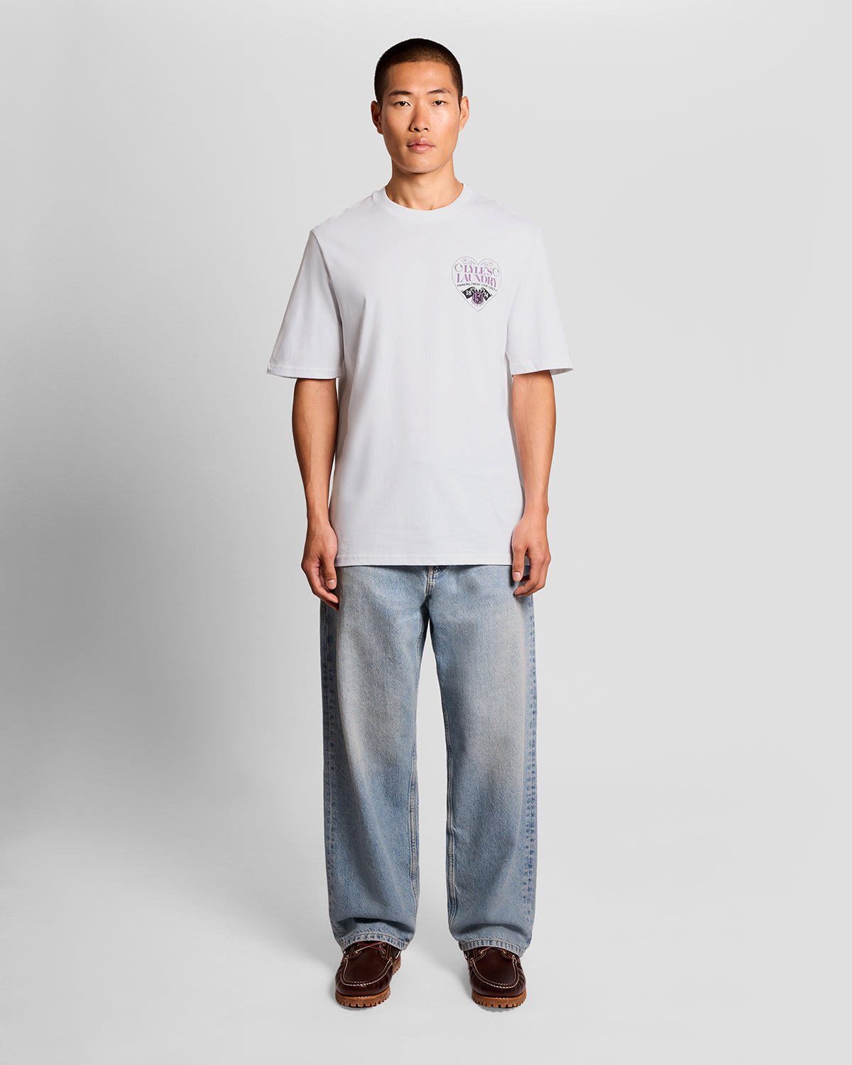 Un homme porte un t-shirt à motif sur la poitrine, de couleur blanche