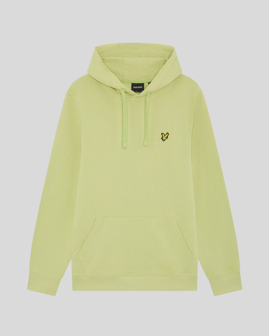 Un homme porte un sweat à capuche Loopback en coton, couleur « Green Grass »