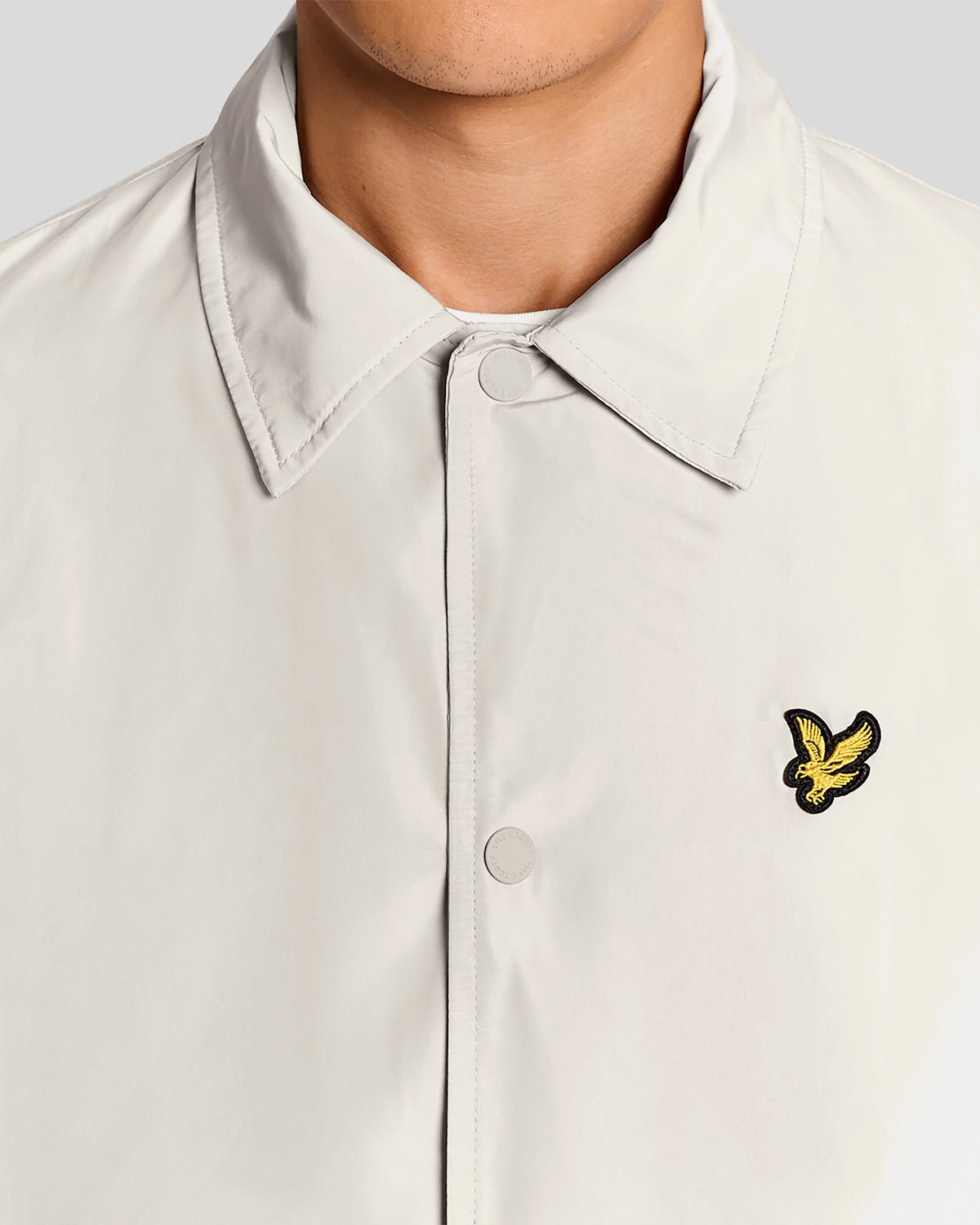 Un homme porte une veste Coach légère de couleur Cove