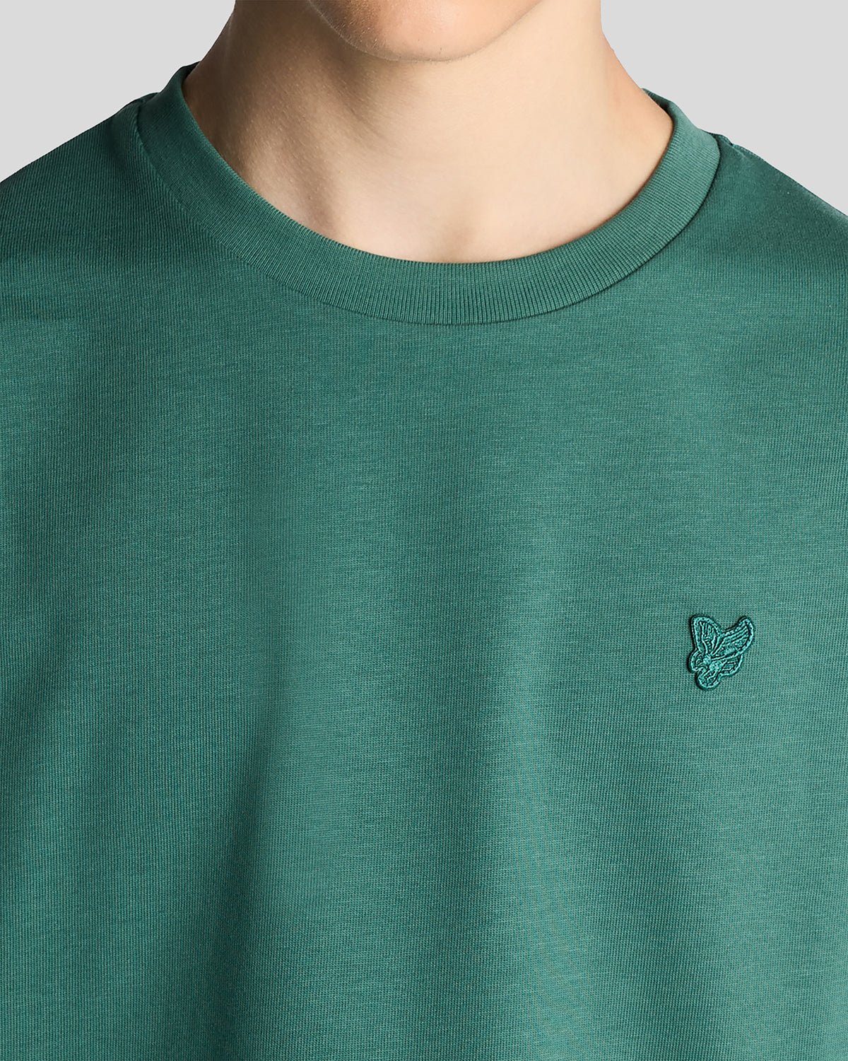 Un homme porte un t-shirt ample épais de couleur Everglade