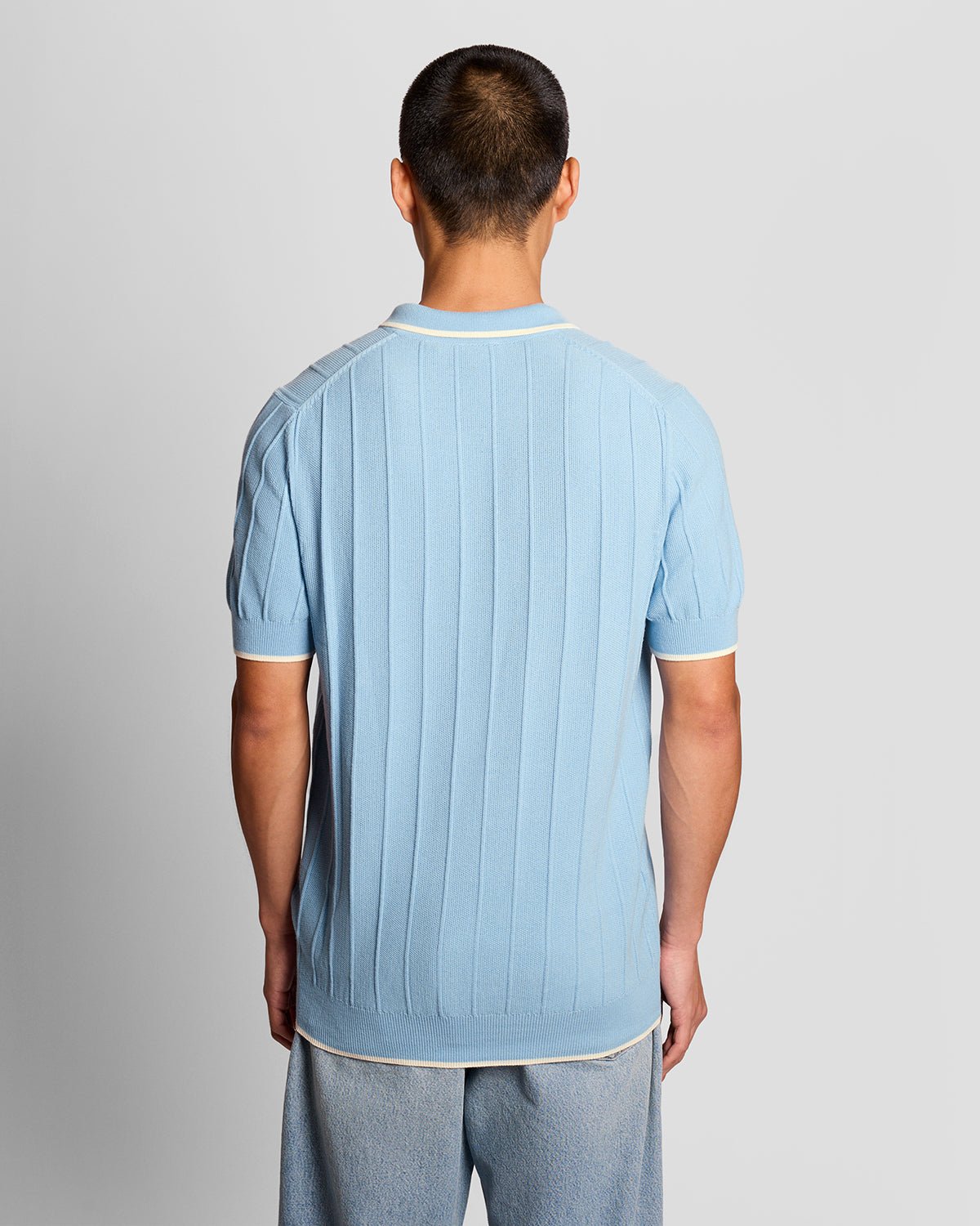 Homme portant un polo en maille piquée à rayures bleu craie