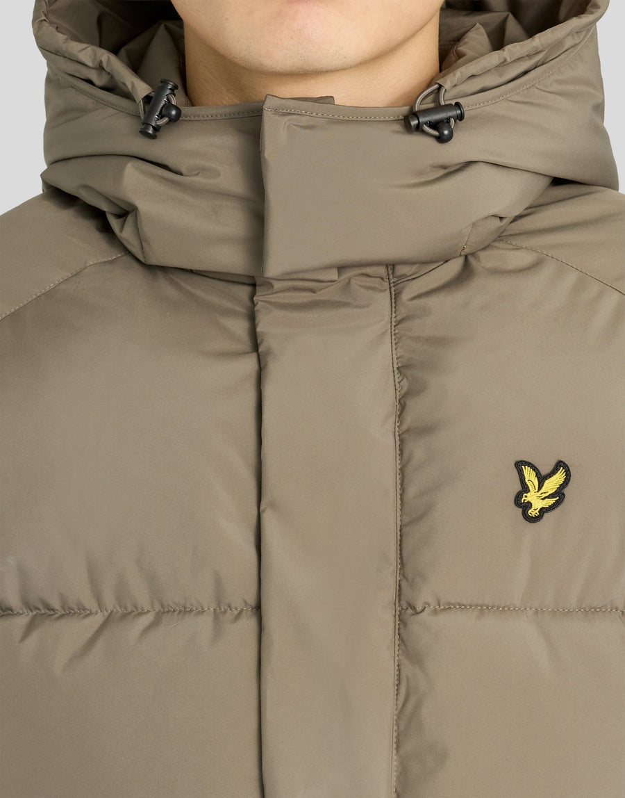Mann trägt eine Kapuzen-Daunenjacke in der Farbe „Khaki Ash“