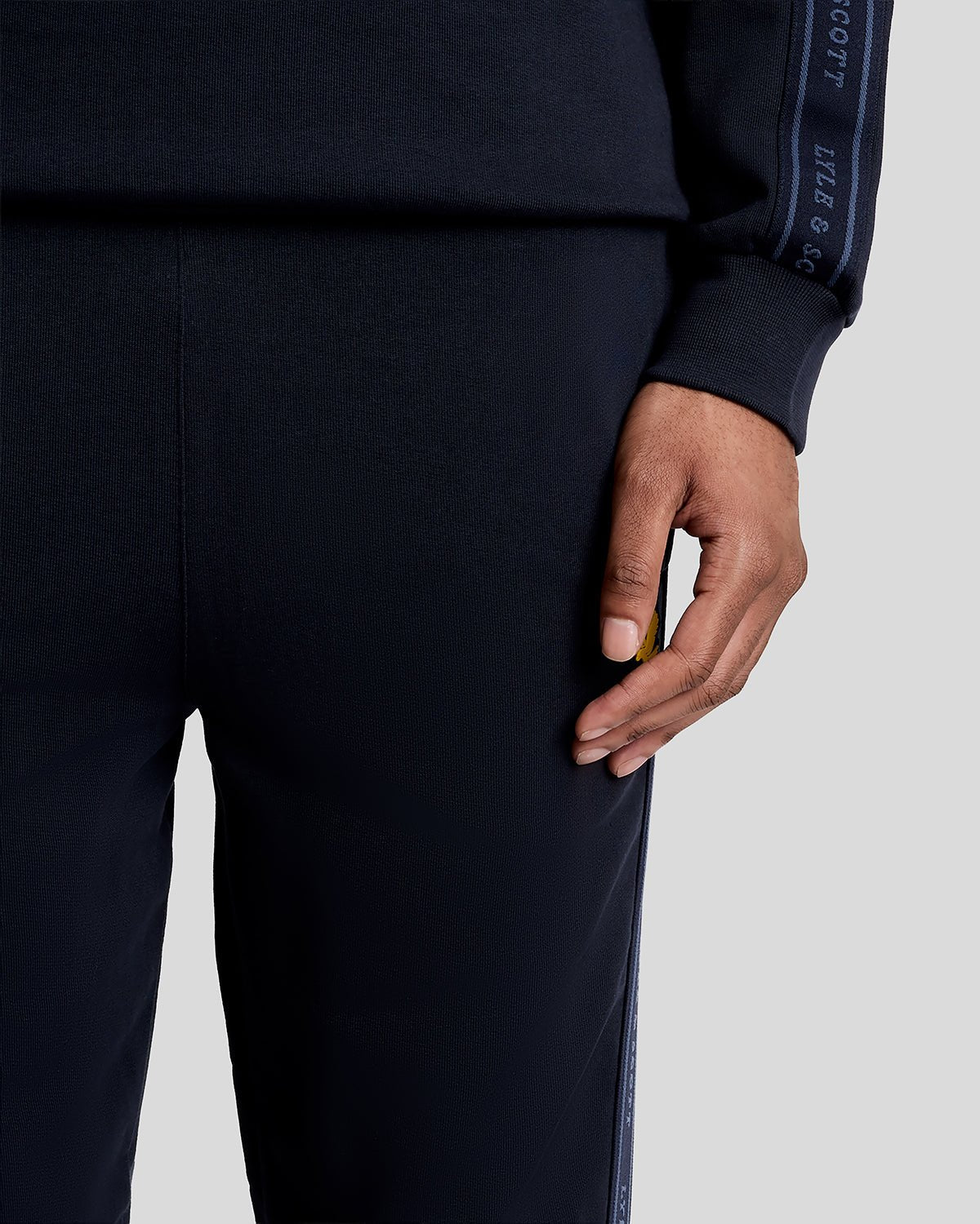 Un homme porte un pantalon de jogging Sports Tape bleu marine foncé