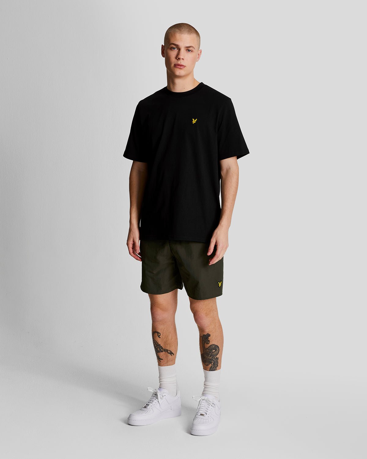 Man wears Plain Swim Shorts in Olive
