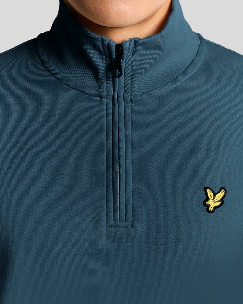 Mann trägt ein „Everyday“ 1/4-Zip-Sweatshirt aus Baumwolle in der Farbe „Rich Teal“