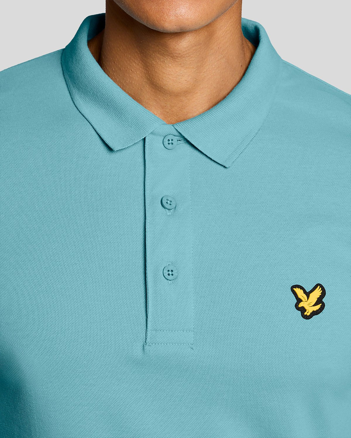 Un homme porte un polo technique bleu aquamarine